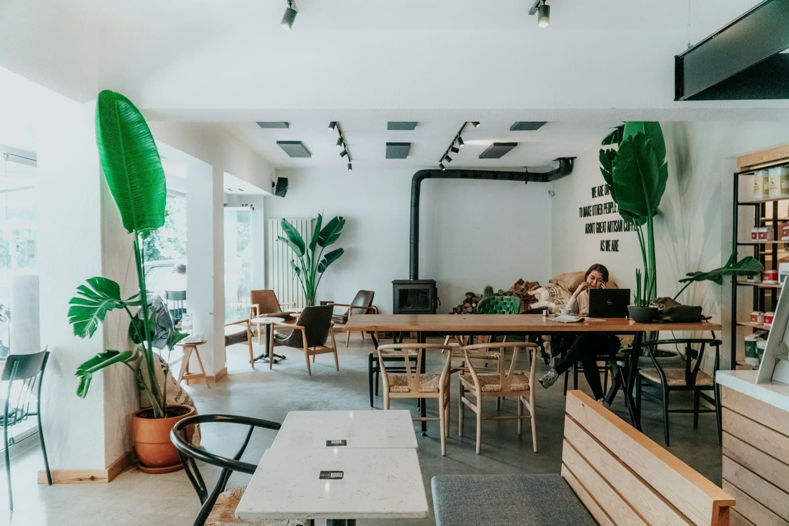 Inside Alpendre: white walls, wooden tables and plants